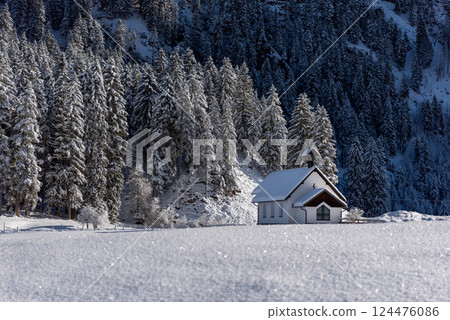 Winter landscape on a sunny day in December with a minimalist snow-covered church 124476086