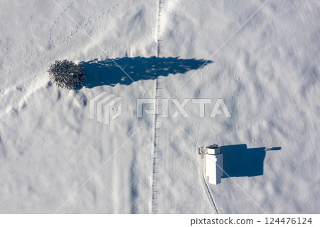 Snowy church minimalist on a snow-covered valley, winter aerial view in the Bavarian Alps, Germany Snowy church minimalist on a snow-covered valley, winter aerial view in the Bavarian Alps, Germany 124476124