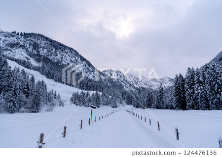 Snow-covered road passing through an alpine valley in the Bavarian Alps, Germany Snow-covered road passing through an alpine valley in the Bavarian Alps, Germany 124476136