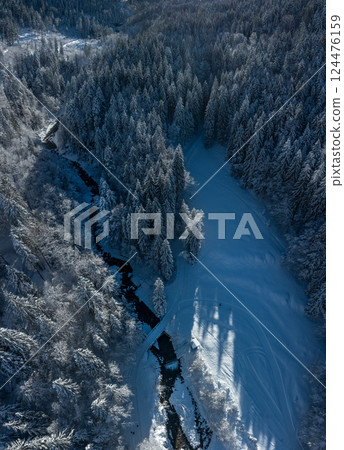 Drone image with snowy forest and mountain river in the Bavarian Alps 124476159