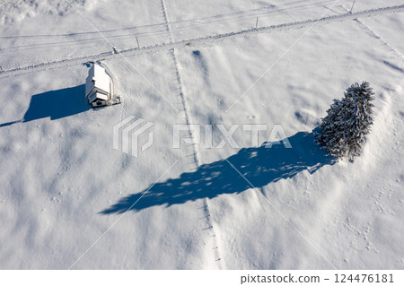 Snow-covered church in bright light, winter aerial view in the Bavarian Alps, Germany Snow-covered church in bright light, winter aerial view in the Bavarian Alps, Germany 124476181