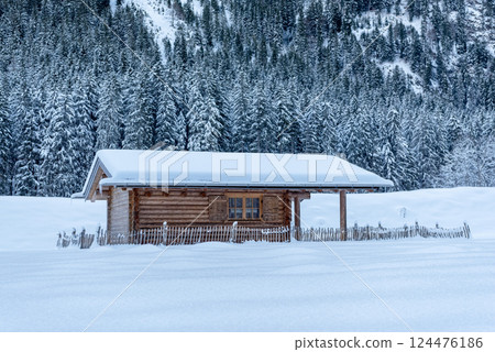 Snow-covered log cabin in deep snow landscape in Bavaria, Germany Snow-covered log cabin in deep snow landscape in Bavaria, Germany 124476186