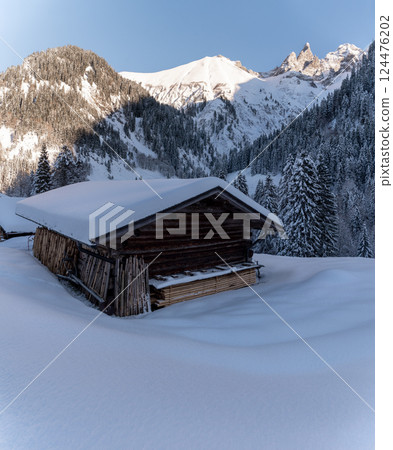 Winter scenery with snow-covered hut and mountain peaks in Bavaria, Germany Winter scenery with snow-covered hut and mountain peaks in Bavaria, Germany 124476202