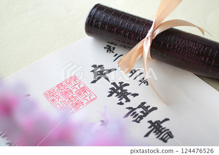 Diploma and cherry blossom petals 124476526