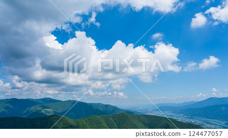 Many white clouds in the blue sky and mountains wrapped in greenery Many white clouds in the blue sky and mountains wrapped in greenery 124477057