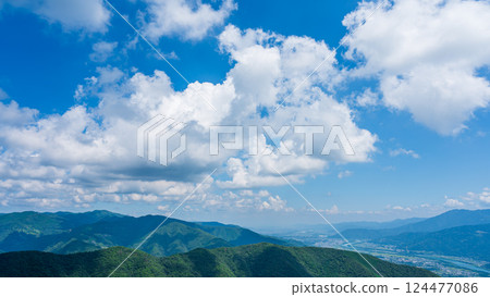 Many white clouds in the blue sky and mountains wrapped in greenery Many white clouds in the blue sky and mountains wrapped in greenery 124477086