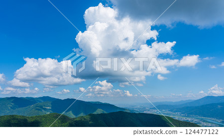 Many white clouds in the blue sky and mountains wrapped in greenery Many white clouds in the blue sky and mountains wrapped in greenery 124477122