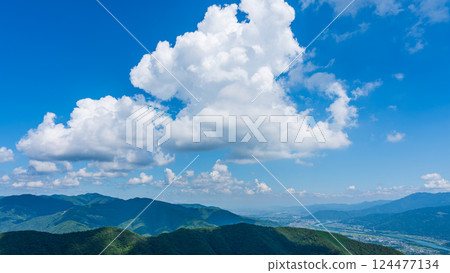Many white clouds in the blue sky and mountains wrapped in greenery 124477134