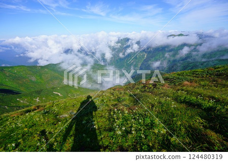 雲霧繚繞的朝日山脈和登山者的影子 雲霧繚繞的朝日山脈和登山者的影子 124480319