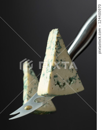 Cheese knife and piece of blue cheese. 124480970
