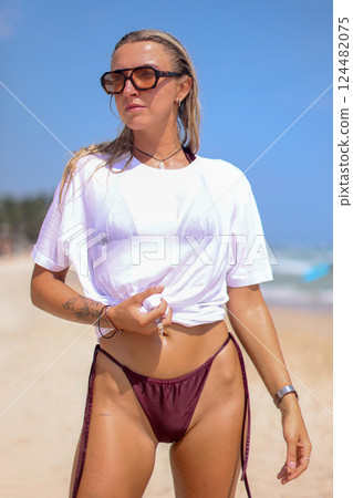 A Stylish Photo of Trendy Beachwear Showcasing a Beautiful Model Posing on the Shoreline A Stylish Photo of Trendy Beachwear Showcasing a Beautiful Model Posing on the Shoreline 124482075
