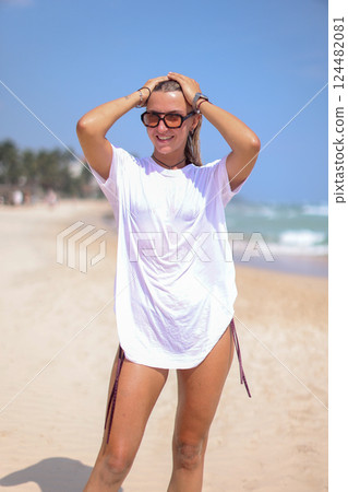 A Stylish Photo of Trendy Beachwear Showcasing a Beautiful Model Posing on the Shoreline 124482081