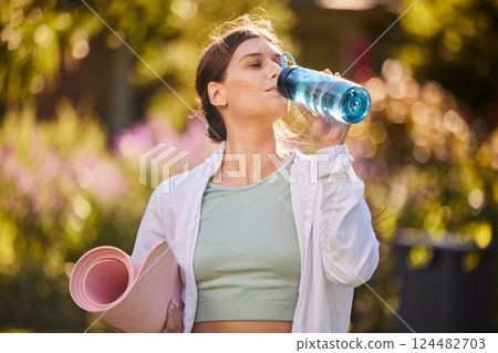 Fitness, woman and water for hydration in yoga for healthy, exercise or workout in the nature outdoors. Female drinking from bottle holding mat for exercising, training and wellness in health sport Fitness, woman and water for hydration in yoga for healthy, exercise or workout in the nature outdoors. Female drinking from bottle holding mat for exercising, training and wellness in health sport 124482703