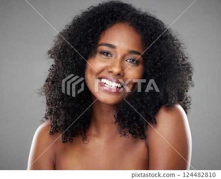 Happy, smile and portrait of a young woman with clean, beautiful and natural hair in a studio. Happiness, beauty and face of girl model with afro from Brazil smiling while isolated by gray background 124482810