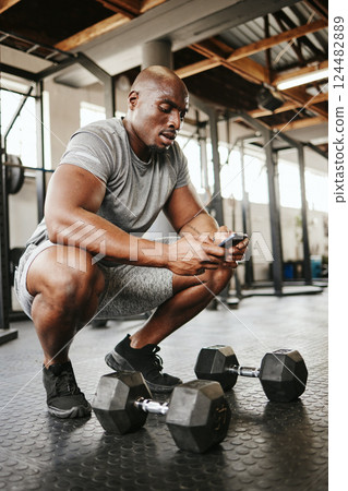 Fitness, phone and online personal trainer at the gym typing or searching on social media in Nigeria. Strong black man, bodybuilder and healthy sportsman networking or texting a digital message Fitness, phone and online personal trainer at the gym typing or searching on social media in Nigeria. Strong black man, bodybuilder and healthy sportsman networking or texting a digital message 124482889