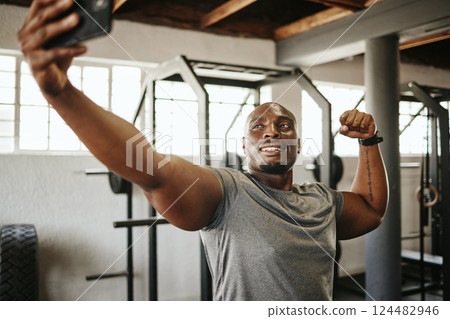 Phone, gym and selfie of black man, exercise and fitness with strong, muscular and smile bodybuilder. Happy instructor with picture, motivated and ready for a good training workout in a health centre 124482946