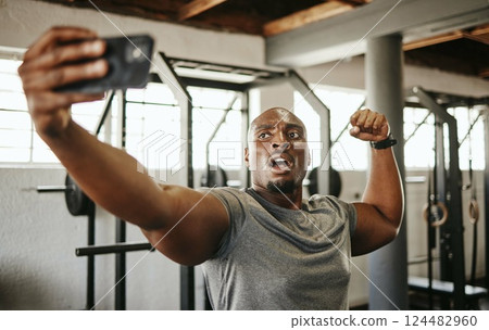 Gym selfie, smartphone and man flexing arm muscle for a post gyming pump bodybuilding exercise for online social media. Black man, fitness workout trainer and bodybuilder training for wellness health 124482960