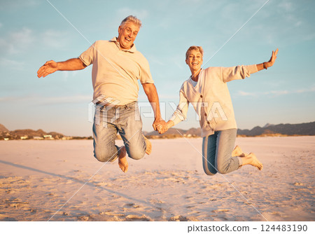 Couple, beach and active seniors hold hands while jumping in sand, happy and excited at sunset. Love, family and freedom with mature man and woman jump in celebration of retirement, travel and energy Couple, beach and active seniors hold hands while jumping in sand, happy and excited at sunset. Love, family and freedom with mature man and woman jump in celebration of retirement, travel and energy 124483190