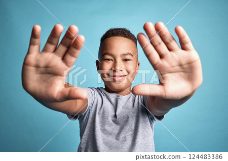 Frame, photographer and hands portrait of child with satisfied smile for creative expression. Inspiration, perspective and creativity in mind of happy African boy with blue studio background. Frame, photographer and hands portrait of child with satisfied smile for creative expression. Inspiration, perspective and creativity in mind of happy African boy with blue studio background. 124483386