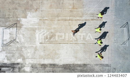 Sports, soccer player and team with coach stretching, working on game fitness, competition warm up or exercise top view. Street football, commitment and man coaching men, athlete or training workout 124483407