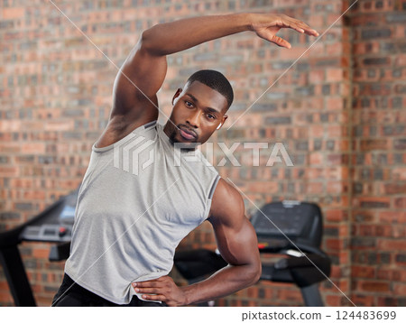 Exercise, black man and stretching for workout, fitness and wellness being healthy, in sportswear and in gym with focus face. African American trainer, athlete or male for health, cardio and training 124483699