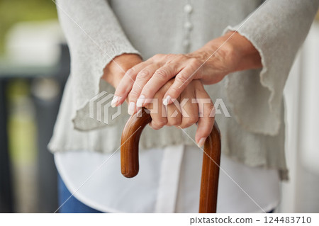 Hands, walking cane and senior woman with disability leaning for help, balance and support at nursing or retirement home. Hand, mature and mobility stick for disabled elderly lady in physical therapy 124483710