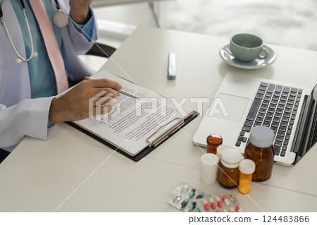 Medical Consultation and Patient Care. A healthcare provider carefully records patient information during a telehealth session. Medical Consultation and Patient Care. A healthcare provider carefully records patient information during a telehealth session. 124483866