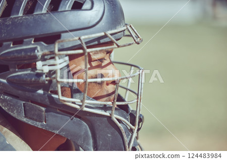 Baseball, sport and helmet with a sports man on a grass pitch or field during a game for exercise or fitness. Workout, training and competition with a male athlete playing sport at an outdoor event 124483984