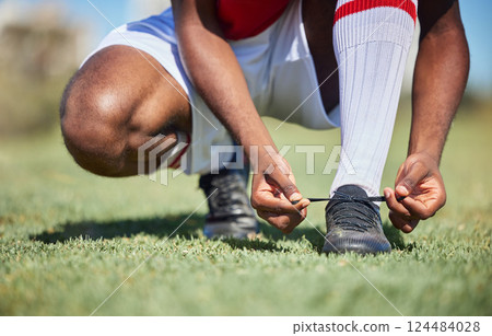Man tie football shoes lace on soccer field, athlete ready for sports training in Portugal and exercise on grass stadium. Young person in uniform on pitch, prepare for game and socks with boots 124484028