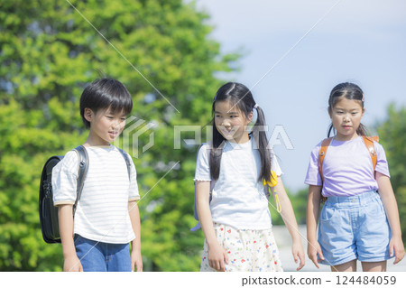 Elementary school student carrying a backpack walking outdoors Elementary school student carrying a backpack walking outdoors 124484059