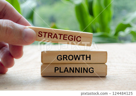 Hand putting Growth Planning text on wooden block. Business strategy and growth concept. Hand putting Growth Planning text on wooden block. Business strategy and growth concept. 124484125