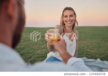 Toast, juice and couple on a date in a park for love in marriage together during summer. Happy, smile and young woman cheers with a drink and a man on a picnic in nature for happiness and peace Toast, juice and couple on a date in a park for love in marriage together during summer. Happy, smile and young woman cheers with a drink and a man on a picnic in nature for happiness and peace 124484239