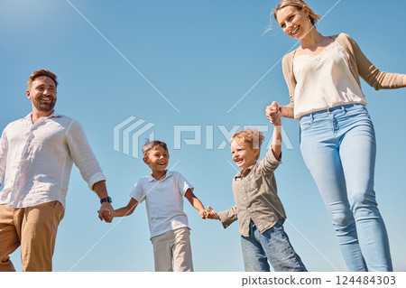 Family, children and sky with a mother, father and boy siblings walking hand in hand outdoor in summer. Freedom, love and kids with a brother holding hands with his parents while on a walk together Family, children and sky with a mother, father and boy siblings walking hand in hand outdoor in summer. Freedom, love and kids with a brother holding hands with his parents while on a walk together 124484303