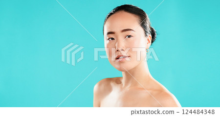 Portrait, skincare and Asian woman with cosmetics, shine and beauty on blue studio background. Japanese person, aesthetic and model with healthy skin, dermatology and grooming with mockup space 124484348