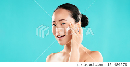 Studio, portrait and Asian woman with cream for skincare, wellness and anti aging benefits with smile. Mockup, female person and apply with cosmetics for beauty, face moisturizer and blue background Studio, portrait and Asian woman with cream for skincare, wellness and anti aging benefits with smile. Mockup, female person and apply with cosmetics for beauty, face moisturizer and blue background 124484378