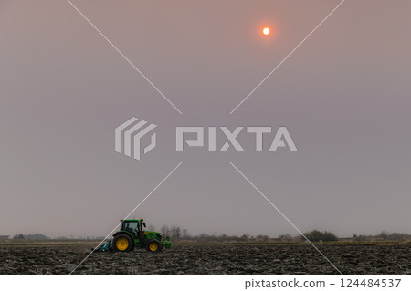 Plowing rice fields with a large tractor early in the morning Plowing rice fields with a large tractor early in the morning 124484537
