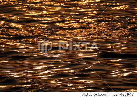 Golden shining water surface 124485948