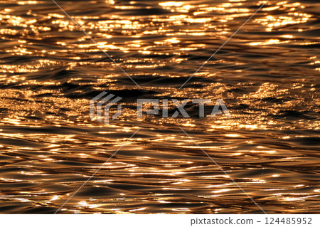 Golden shining water surface Golden shining water surface 124485952