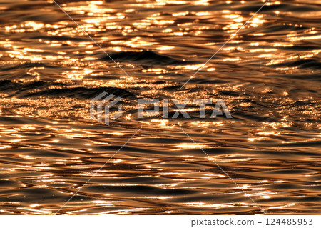 Golden shining water surface Golden shining water surface 124485953