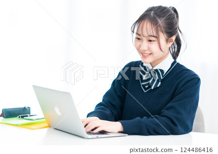 一名高中女生在客廳面對電腦 124486416
