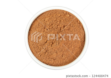 Cinnamon powder in ceramic bowl isolated on white background. Top view. Flat lay 124488474