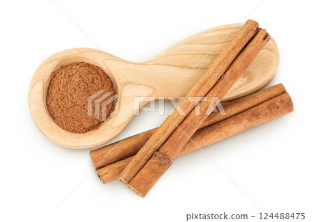 Cinnamon sticks with powder in wooden spoon isolated on white background. Top view. Flat lay. 124488475