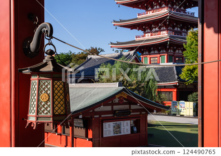 Traditional Japanese lantern with metal details hangs against the five story pagoda of Senso-ji 124490765