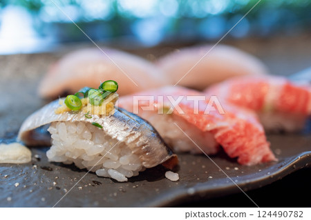 Nigiri sushi with mackerel topped with green onions and grated ginger Nigiri sushi with mackerel topped with green onions and grated ginger 124490782