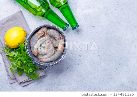 Fresh raw shrimps, accompanied by sprigs of fresh parsley and juicy lemon Fresh raw shrimps, accompanied by sprigs of fresh parsley and juicy lemon 124491150