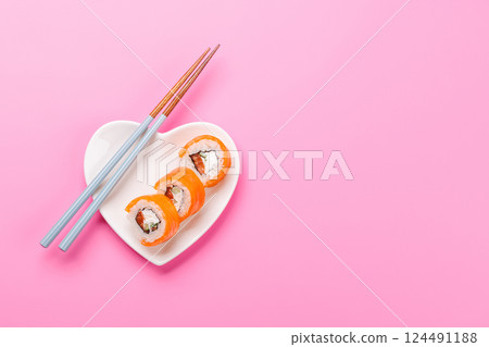 A heart-shaped plate filled with delicious sushi, accompanied by chopsticks A heart-shaped plate filled with delicious sushi, accompanied by chopsticks 124491188