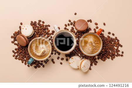 A steaming cups of freshly brewed coffee surrounded by rich, aromatic roasted coffee beans 124491216
