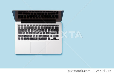 A laptop placed against a blue background in a flat lay style A laptop placed against a blue background in a flat lay style 124491246