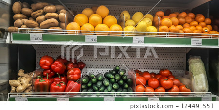 Vegetable shelves in a store. The store has vegetables and fruits beautifully displayed on shelves. Vegetable shelves in a store. The store has vegetables and fruits beautifully displayed on shelves. 124491551