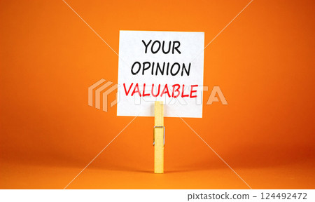 Your opinion valuable symbol. Concept words Your opinion valuable on beautiful white paper on clothespin. Beautiful orange background. Business your opinion valuable concept. Copy space. 124492472